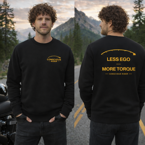 “Black motorcycle crewneck sweatshirt with Conscious Rider front logo and ‘Less Ego More Torque’ graphic on the back, worn by a man on a mountain road.”
